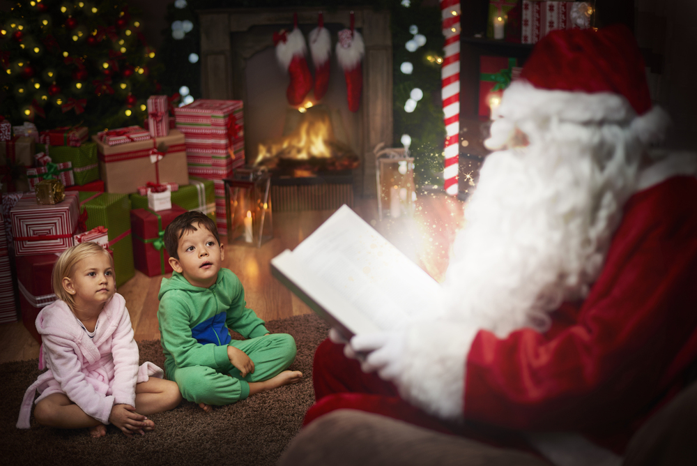 Pere noël lit des histoires à deux enfants